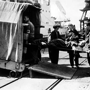 A wounded soldier is carried aboard a hospital ship 1945 France WW2