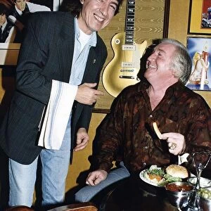 Bill Wyman serves Jimmy Jones comedian at Sticky Fingers restaurant. May 1989