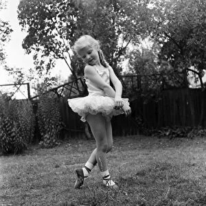 Young girl Penny Brown practising her Ballet dancing wearing a tutu in the back garden