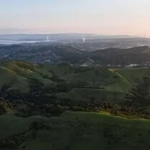 Morning sunlight shines on the green hills of the East Bay in Northern California. This open area, east of San Francisco, is green in the winter