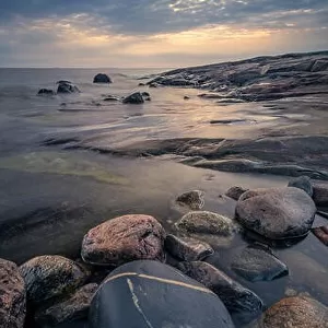 Scenic sea view with rocky coastline and sunset at autumn evening in Finland