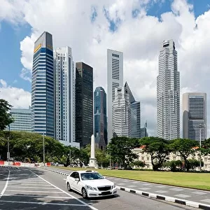 Taxi cab driving in road in Singapore downtown with Singapore skyscrapers building in background. Asia
