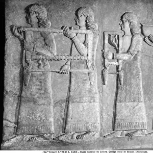 Carved stone with the royal court of Sargon, taken from Nimrud: work preserved in the Louvre Museum, Paris