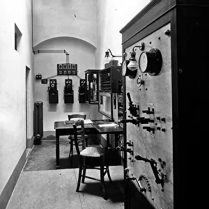 Corridor with telephones and an electrical control panel. Inside view of the Credito Toscano, Florence