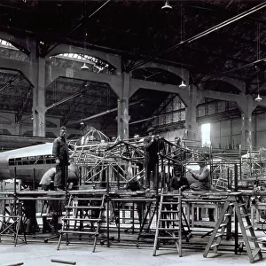 Workers building an airplane in an aeronautic workyard