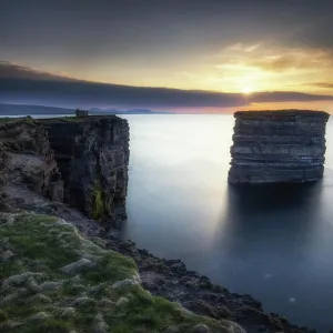 Paisaje costero con acantilados y farallón en el atardecer, Condado de Mayo, Irlanda.