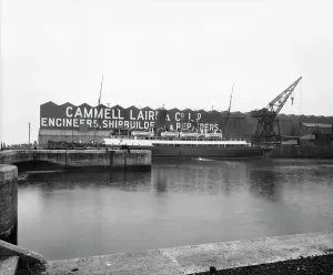 Prints of Cammell Laird and Co shipyard, Birkenhead. Exterior view across the outer basin looking towards a ferry moored outside the Cammell Laird buildings Iconic Photographers of England - Historic Image Collections: Cammell Laird Shipyard Print, Birkenhead