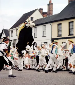 Prints of Town Street, Thaxted, Essex. A group of morris dancers and a unicorn hobby horse at a Thaxted Morris Ring meeting. Photographed by John Gay in the mid-1960s Essex Prints: Print of Morris Dancers in Thaxted, Essex
