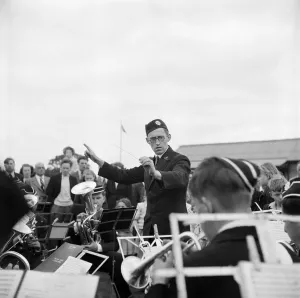 Print of a man conducting a brass band at Laing Sports Ground