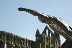 Prints of Borghese Gladiator, Whitby Abbey, Whitby, Scarborough, North Yorkshire. Detail of the Gladiator sculpture at Whitby Abbey, with the abbey ruins behind Sculpture Prints: Print of the Borghese Gladiator at Whitby Abbey