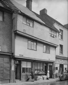 Prints of 6 - 7 Gosford Street, Coventry. The exterior of shop premises at 6 and 7 Gosford Street showing foodstuffs displayed outside number 7 and a tarpaulin covering damage to the roof of number 6 Coventry Prints: Print of Gosford Street Coventry, 1941