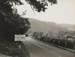 Prints of TINTERN ABBEY, MONMOUTHSHIRE, WALES. A view looking north-west towards Tintern Abbey, with a road sign displaying Tintern in the foreground Historic Photos of England - People, Places and Everyday Life: Tintern Abbey Print: A north-west view of the Cistercian abbey ruins