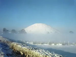 Prints of SILBURY HILL, Avebury, Wiltshire. View from the east looking towards the snow covered mound. Part of the Avebury World Heritage Site Monuments And Memorial Prints: Silbury Hill Print: East-facing View