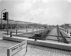 Prints of THE SHOPPING CENTRE, SILBURY BOULEVARD, MILTON KEYNES. A view looking south west along Silbury Boulevard from the junction with Secklow Gate showing the Milton Keynes shopping centre Towns and Cities of England - Streets, Skylines and Urban Life: Print of Milton Keynes shopping centre, Silbury Boulevard