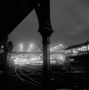Prints of KINGS CROSS STATION, London. The train sheds at Kings Cross Station seen illuminated at night time from the platform of the former York Road station. Photographed by John Gay. Date range: 1960-1972 Transport Prints: Print of Kings Cross Station at night