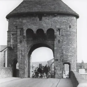 Monnow Bridge Print, a photograph of a man leading a horse and cart through the Monnow Gate