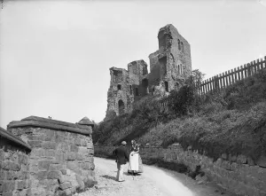 Prints of SCARBOROUGH CASTLE, NORTH YORKSHIRE. An elderly couple conversing on a lane beside the keep of Scarborough Castle Historic Photos of England - People, Places and Everyday Life: Scarborough Castle Print CC76_00637