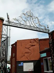 Prints of The Oval Cricket Ground, Kennington, Lambeth, Greater London. The Hobbs Gates at the Oval Cricket Ground, with the red brick sculpture commemorating English cricketer Leonard Hutton beyond Sculpture Prints: The Oval Cricket Ground, Kennington, London - PLA01_03_0567 Print