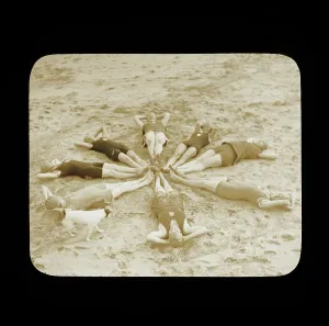 Prints of A group of female swimmers lying in a circle on the beach probably at Clacton-on-Sea, perhaps doing sit-ups, 1920s. Photographer: Norman Kingsley Harrison Historic Images 1920s To 1940s Prints: Norman Kingsley Harrison Print of Female Swimmers on Beach, circa 1920s
