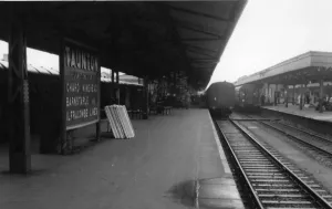Prints of A view of the platforms at Taunton station in Somerset, c.1950s, showing a station sign directing passengers to the Chard, Minehead, Barnstaple and Ilfracombe lines Somerset Station Prints: Taunton Station Print, 1950s Black and White Photograph