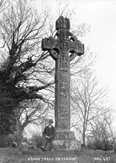 Prints of Arboe Cross, Co Tyrone - a standing cross with man to the left for scale. (Location: Northern Ireland: County Tyrone: Ardboe). Date: circa early 1900s Map Prints: Arboe Cross Print, Northern Ireland, circa early 1900s
