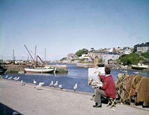 Artist at work on a canvas, Brixham Harbour, Devon Artist at work on a canvas, Brixham Harbour, Devon