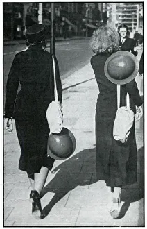 Backs of two walking girls holding helmets, September 1939 Backs of two walking girls holding helmets, September 1939