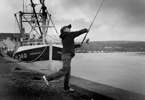 Boy casts his fishing line into River Dee at Kirkcudbright Boy casts his fishing line into River Dee at Kirkcudbright