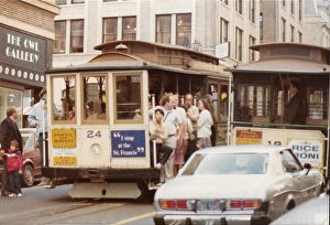 Two cable carts on a busy street in San Francisco Two cable carts on a busy street in San Francisco