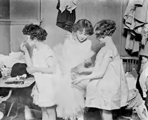 Prints of Little girl mannequins, child models, putting make-up on in their dressing room in Paris, France, presumably for some kind of fashion show or photo shoot. Date: early 1930s Fashion Prints: Early 1930s Parisian Child Models in Dressing Room Print