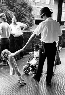 Children play with policeman in a block of flats in Brixton Children play with policeman in a block of flats in Brixton