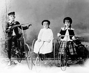 Three children posed with bicycle and tricycles in America Three children posed with bicycle and tricycles in America