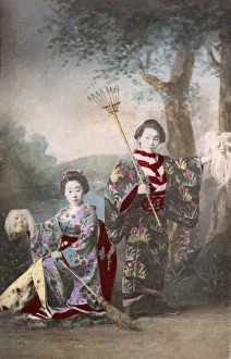 Chinese Actors holding up masks, a rake and a broom Chinese Actors holding up masks, a rake and a broom