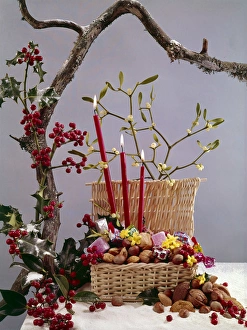 Christmas arrangement of candles, holly, mistletoe and nuts Christmas arrangement of candles, holly, mistletoe and nuts