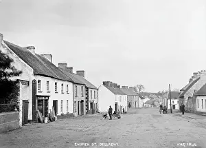 Prints of Church St. Bellaghy - a rural street scene with thatched buildings and shop fronts, people and horse vehicle. (Location: Northern Ireland; County Londonderry; Bellaghy). Date: circa early 1900s Derry Prints: Rural Northern Ireland Print circa Early 1900s