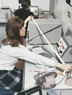 Technician At Work Prints: A computer technician with data tape