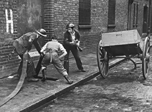 WW2 Firefighters In Action Prints: Connecting up a hosepipe during the Blitz