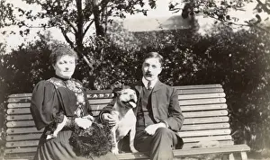 Man And Woman Sitting Together Prints: Couple on a bench with a dog