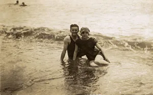 Couple sitting in surf - British seaside candid photograph Couple sitting in surf - British seaside candid photograph