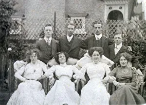Four couples posing for a photograph in a suburban garden Four couples posing for a photograph in a suburban garden