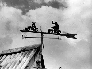 Prints of An unusual cyclists weathervane, seen at Toft, Cambridgeshire, England. Date: 1930s Toft Prints: Cyclists Weathervane Print, Toft, Cambridgeshire, 1930s