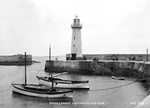 Prints of Donaghadee Lighthouse and Pier - a view of the Lighthouse and pier with boats in the foreground. (Location: Northern Ireland; County Down; Donaghadee). Date: circa early 1900s Donaghadee Prints: Donaghadee Lighthouse and Pier Print - Early 1900s
