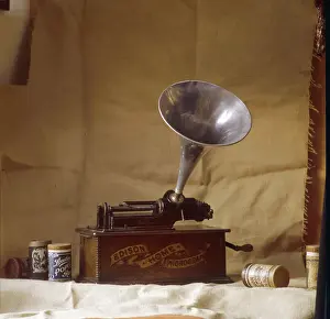Prints of An early Edison phonograph, using grooved wax cylinders, shown beside the instrument Thomas Edison Prints: Early Edison Phonograph Print: Grooved Wax Cylinder and Instrument