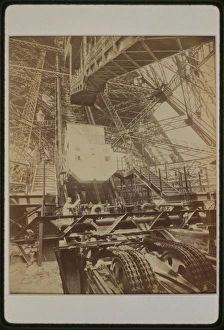 Eiffel Tower machinery with man beside wheel that raises ele Eiffel Tower machinery with man beside wheel that raises ele