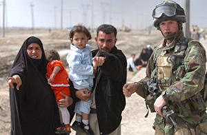 A family of Iraqi civilians seek the help of a soldier A family of Iraqi civilians seek the help of a soldier