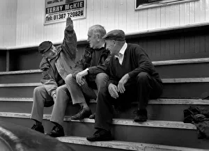 Three farmers chat while waiting for a sheep sale Three farmers chat while waiting for a sheep sale