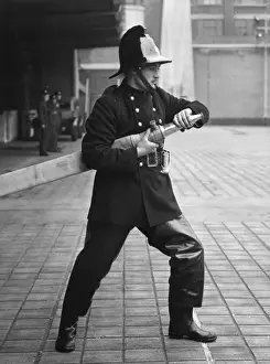 Historical Firefighting Equipment Prints: Firefighter taking part in a hose training drill