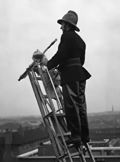 LFB Service History Prints: Firefighter using hook belt at top of ladder