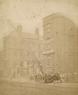 Firefighters in action in a street with a wheeled ladder Firefighters in action in a street with a wheeled ladder