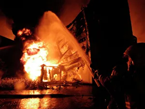 Firefighters working at scene of large warehouse fire Firefighters working at scene of large warehouse fire